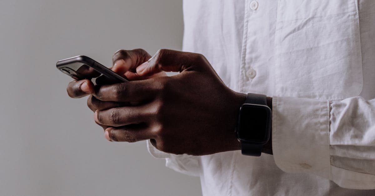 Persoon typt op smartphone met smartwatch om, WhatsApp gebruiken in buitenland met een esim.