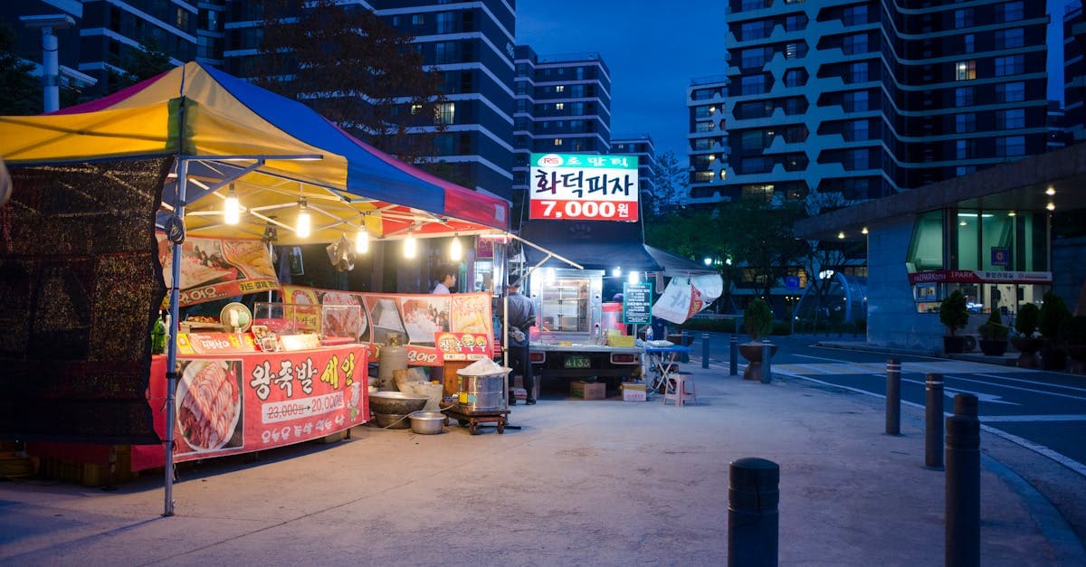 夜の韓国屋台に並ぶ定番メニューの数々、ネオンが輝く都市の景色を背景に