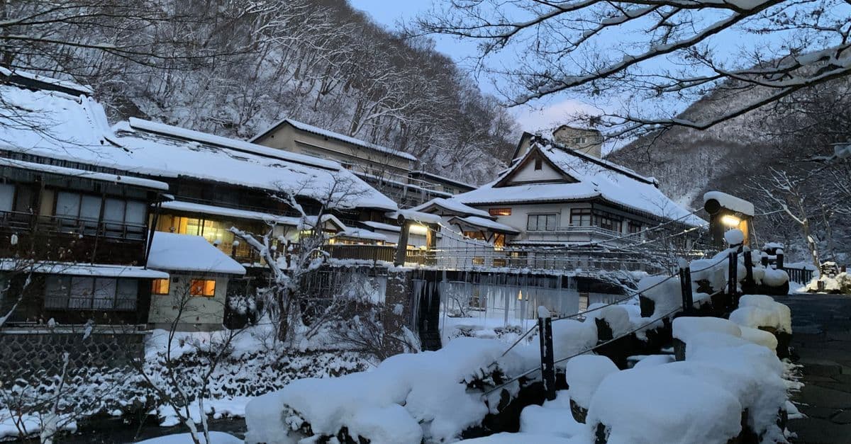 Snow-covered historic village in Takayama at twilight, a hallmark of winter in Japan for American travelers.
