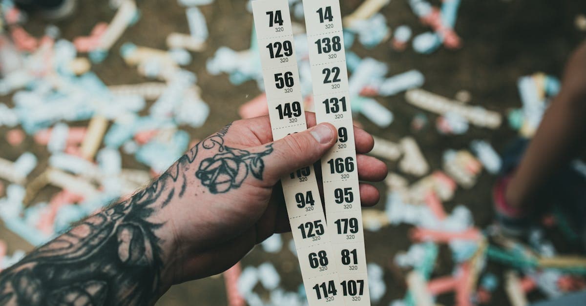 Bàn tay xăm cầm tập vé số giữa pháo giấy lễ hội, minh họa cách đọc kết quả xổ số