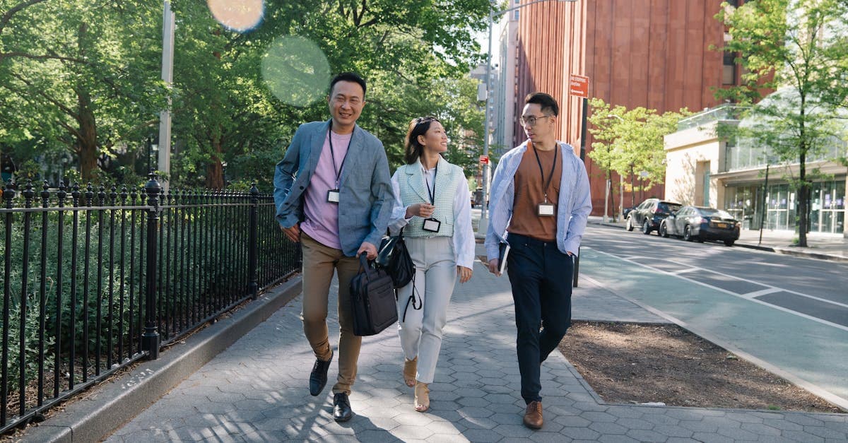 Three people walking on a sunny city street, staying connected while exploring on a cheap city break