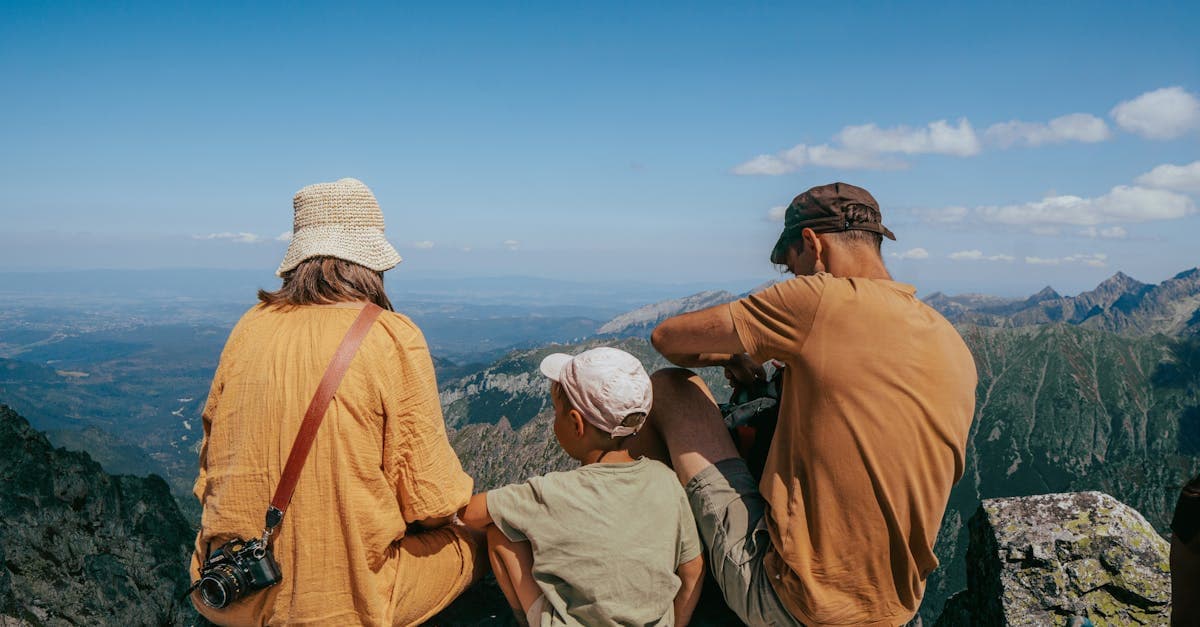 Rodzina siedząca na skale i podziwiająca panoramę Tatr — planowanie internetu za granicą podczas wakacji.