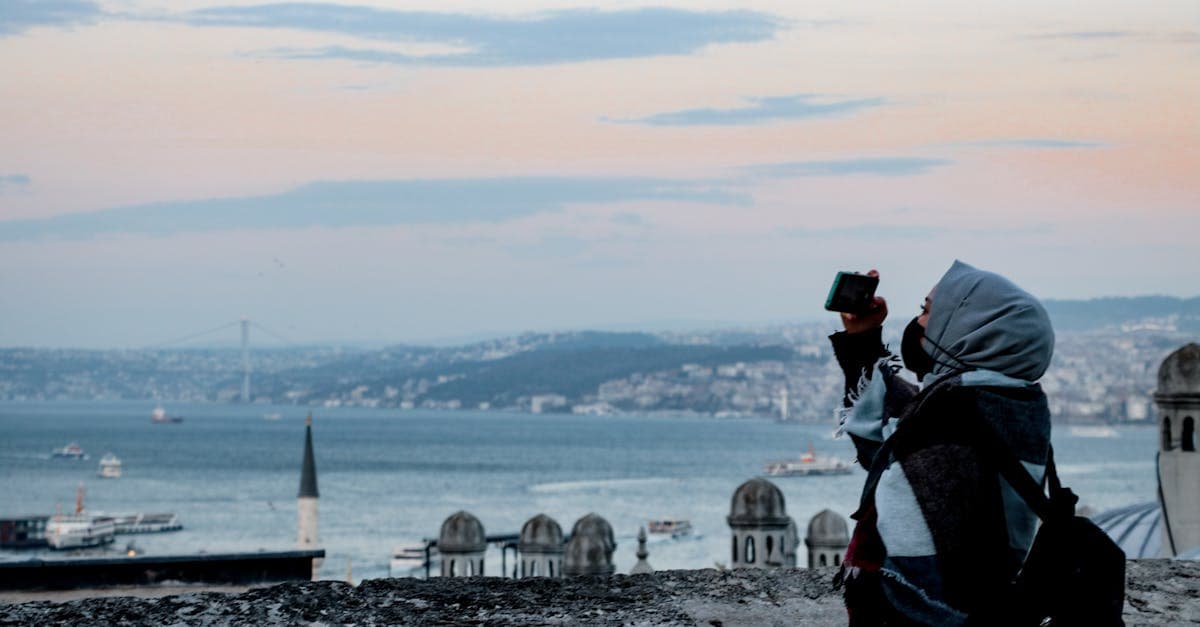 İstanbul Boğazı'nda gün batımında fotoğraf çeken başörtülü kadın, normal SIM ile eSIM farkını keşfeden gezgin