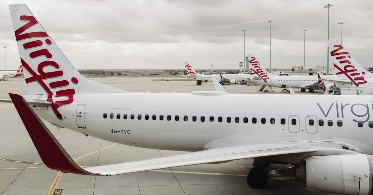 Virgin Australia Boeing 737 aircraft parked at Melbourne Airport under cloudy skies.