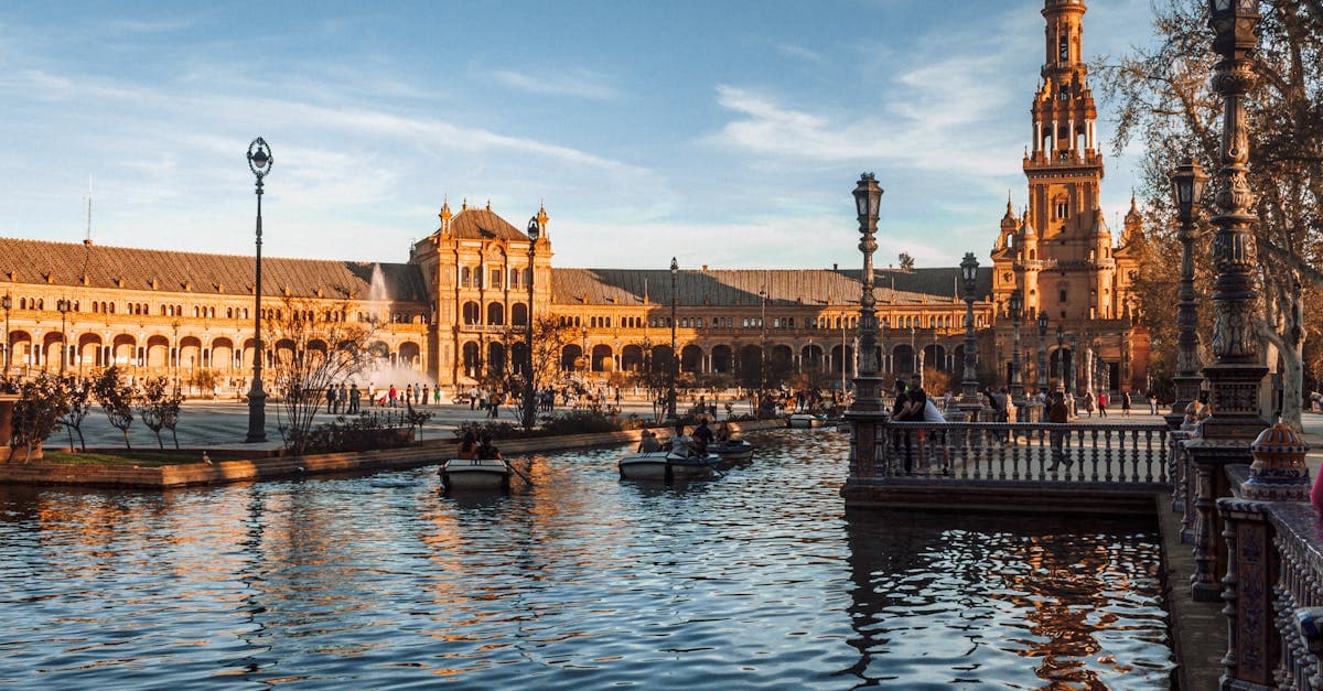 Solnedgångsutsikt över Plaza de España i Sevilla med vackra spegelbilder i kanalen – planera din resa till Spanien.