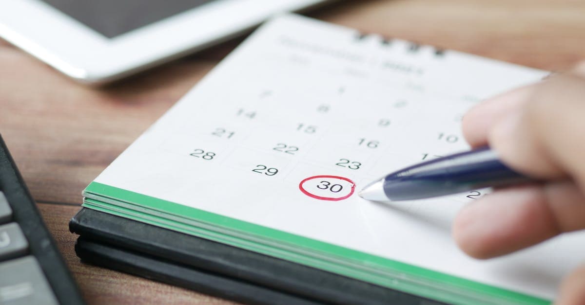 Hand marking travel dates on a calendar while planning the best time to visit Bali month by month