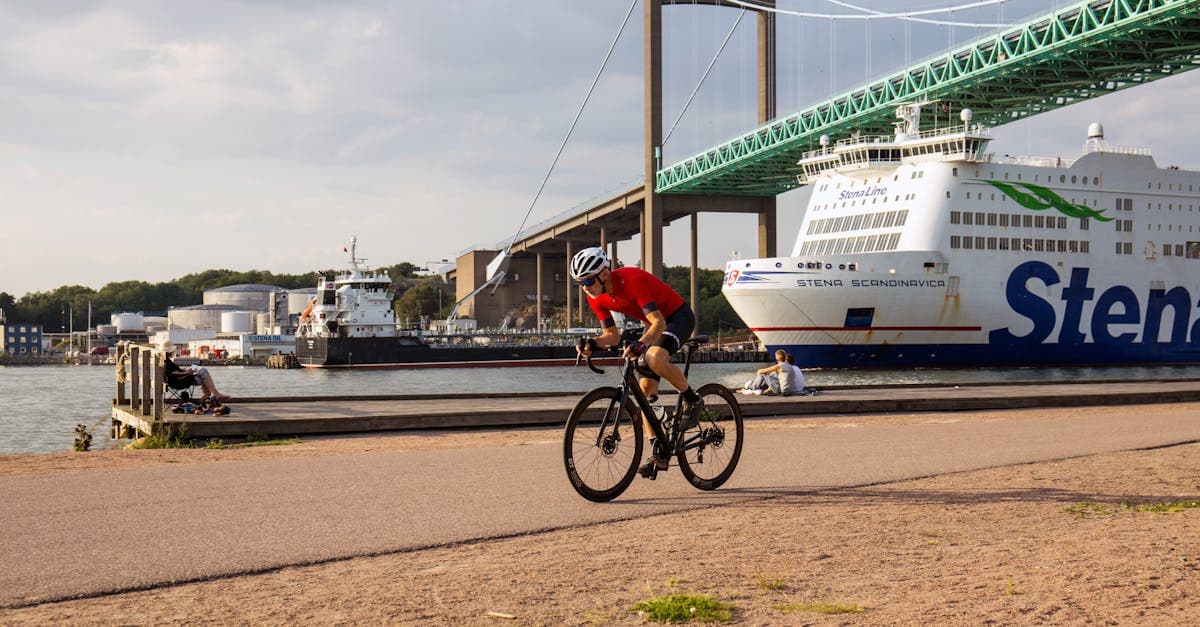 Man cyklar längs kajen med bro och färja i bakgrunden – gratis things to do in gothenburg