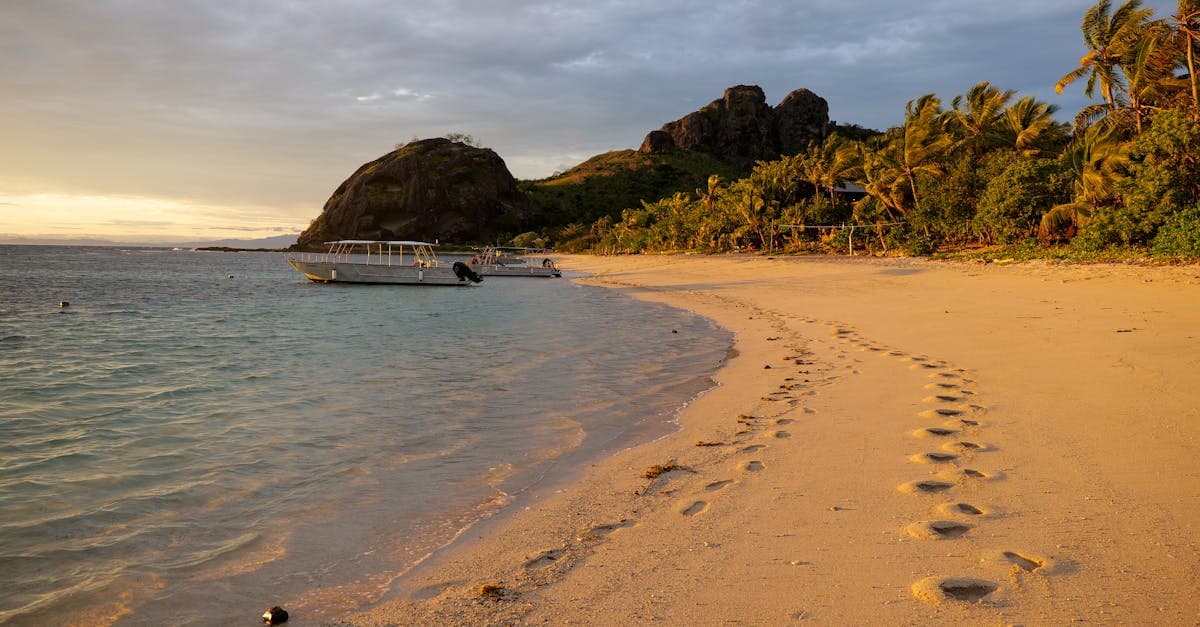 Yasawa Islands beach at sunset with footprints in the sand, highlighting fiji holiday packages at a glance