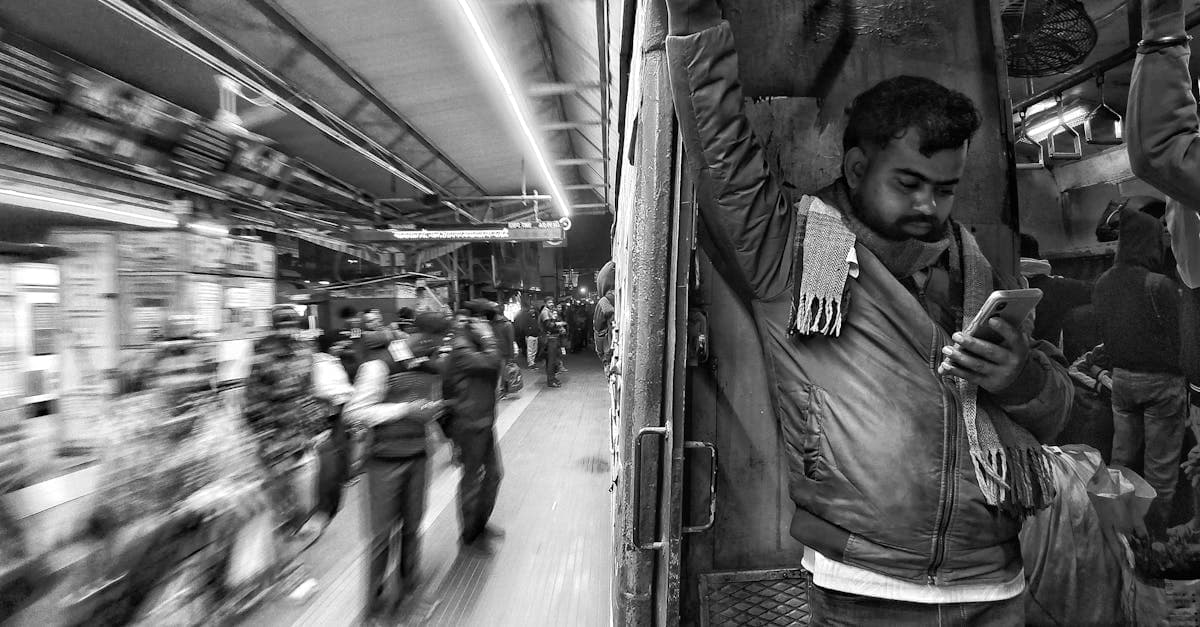 Man checking mobile signal on a moving train in India, where remote areas challenge portable wifi coverage