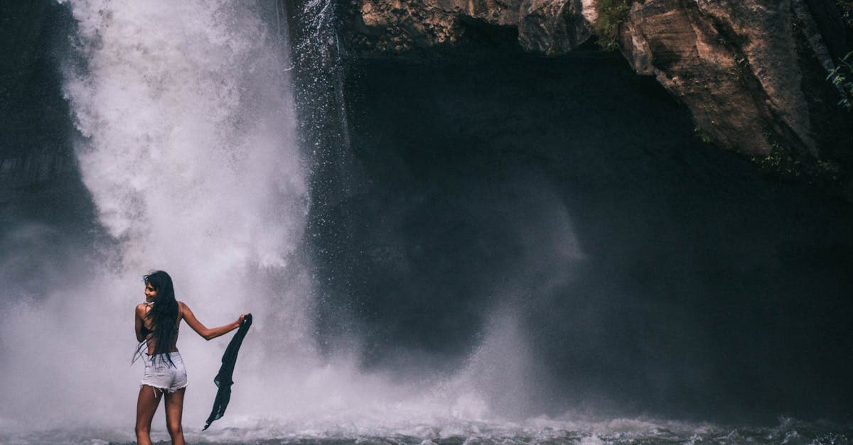 Woman standing before a magnificent Bali waterfall, exploring the real safety risks travellers face on holiday