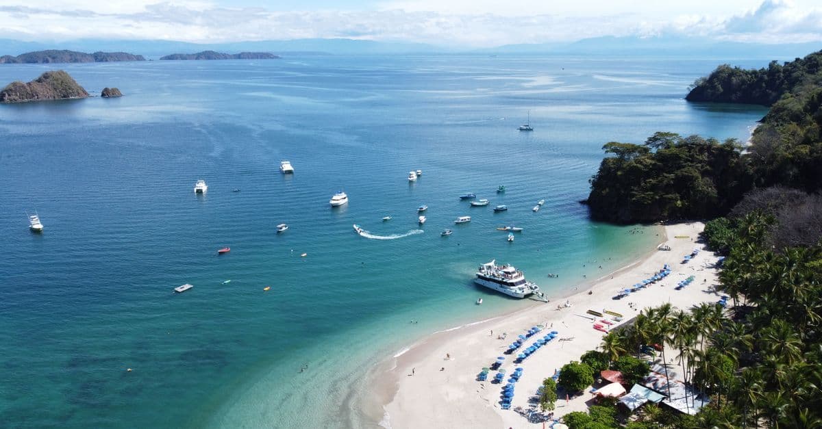 Playa Blanca boats and lush greenery along Costa Rica's Central Pacific coast near Manuel Antonio.