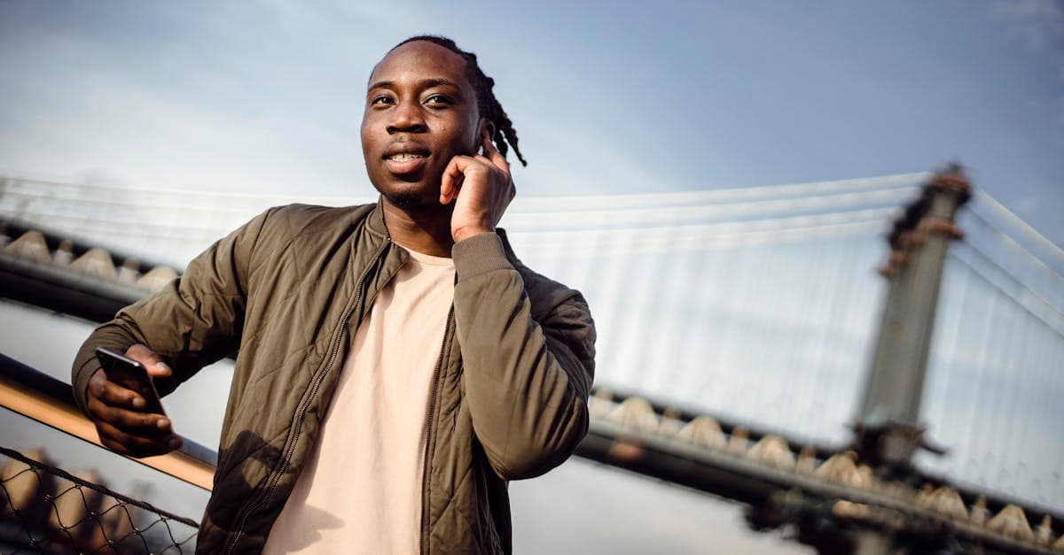 Young man making a wireless call outdoors, comparing T-Mobile international roaming day pass and week pass pricing.