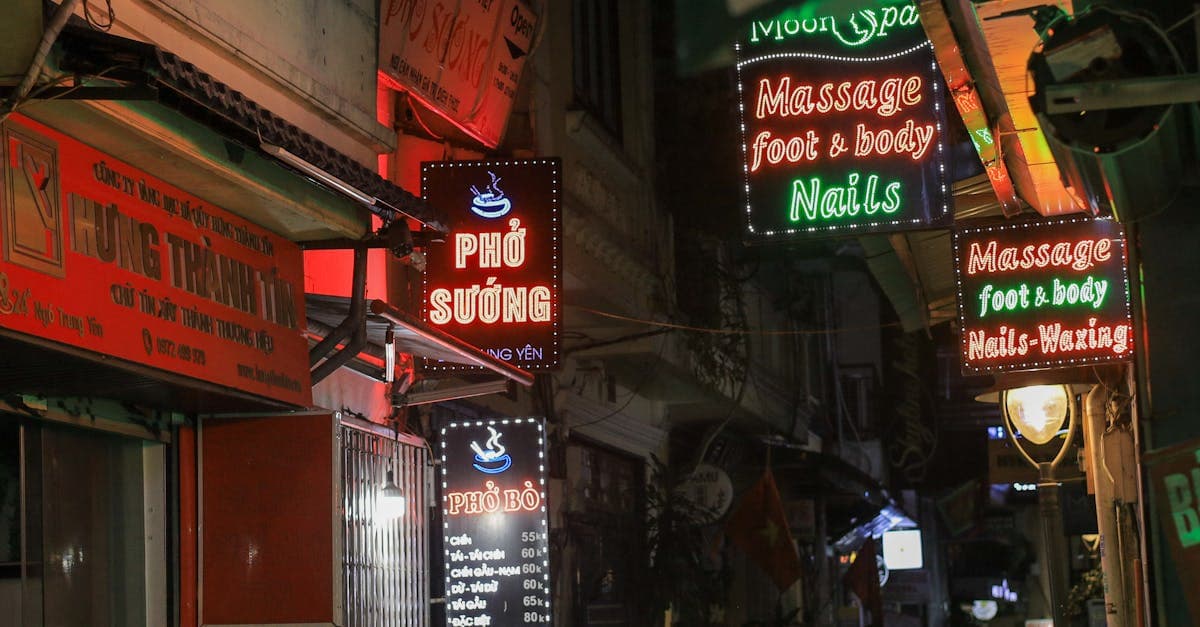 Farverige neonskilte oplyser en travl Hanoi-gyde om aftenen, det bedste tidspunkt for streetfood