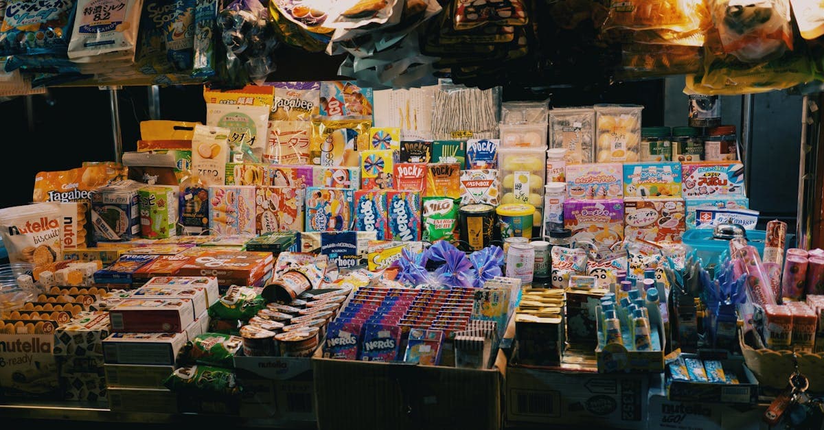 鮮やかな照明に照らされた夜市のお菓子とスナックスタンド、韓国の夜市を楽しむ旅行者の様子