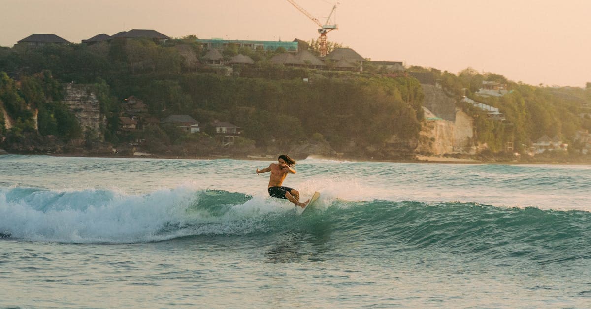 Surfeur chevauchant les vagues au coucher du soleil sur une plage de Bali, meilleure période pour surfer en saison sèche