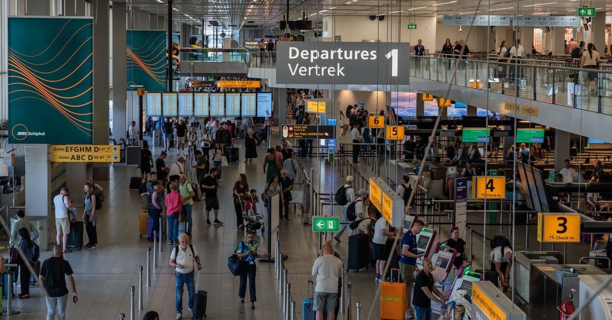 Busy departure hall at Amsterdam Schiphol Airport welcoming travellers from the UK.