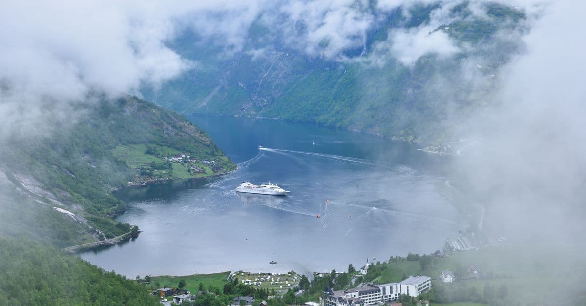 Aerial view of a cruise ship on Geiranger Fjord, showcasing why a balcony cabin enhances a norwegian fjords cruise