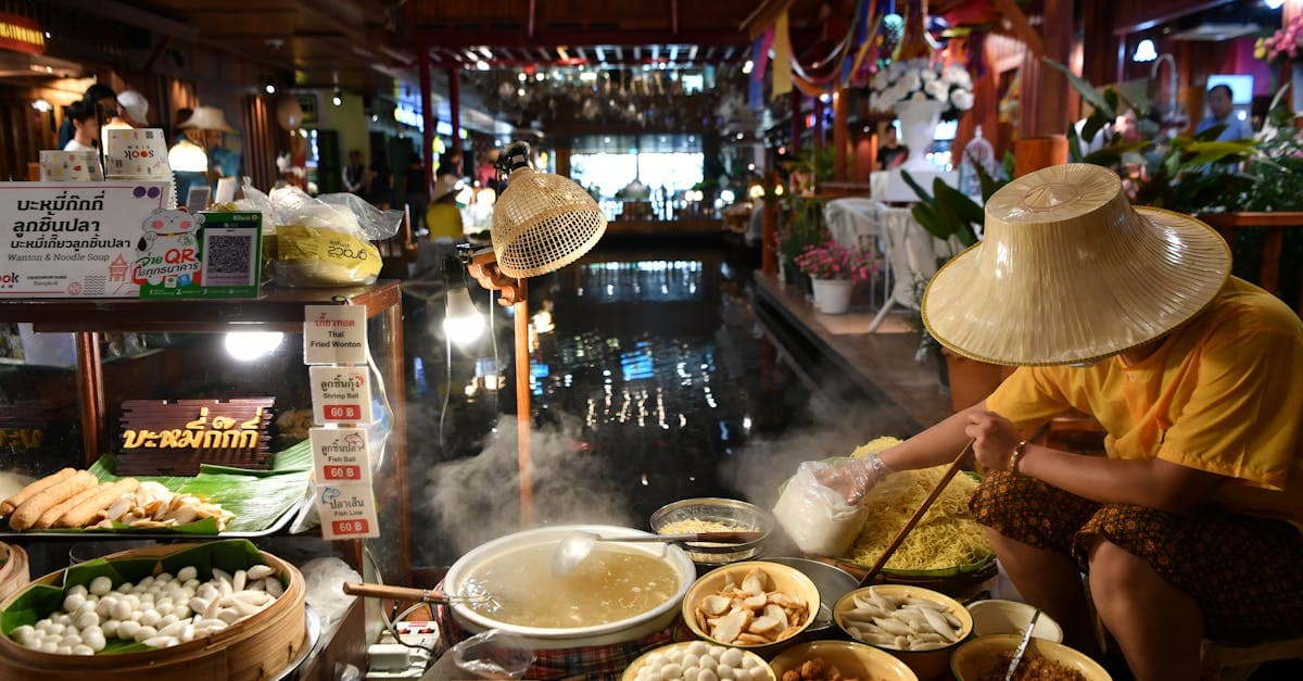 แม่ค้าไทยปรุงก๋วยเตี๋ยวสดในตลาดในร่ม ย่านยอดนิยมสำหรับ street food bangkok thailand