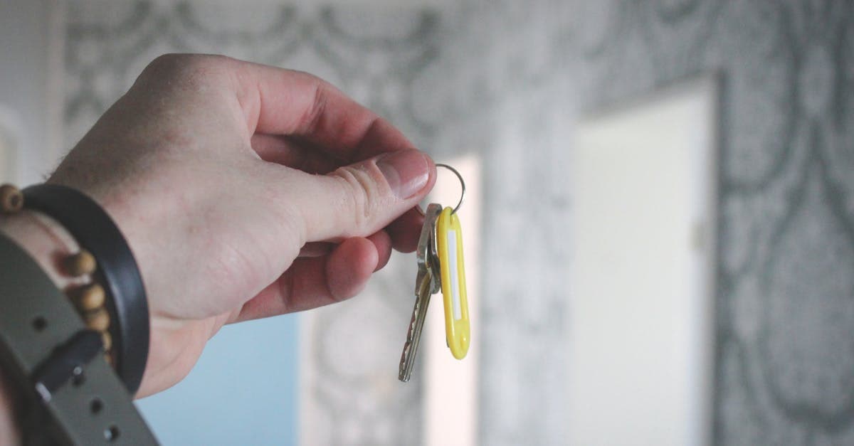 Hand hält einen Hausschlüssel – Schritt-für-Schritt beim Willhaben Haus kaufen vom Inserat bis zur Übergabe