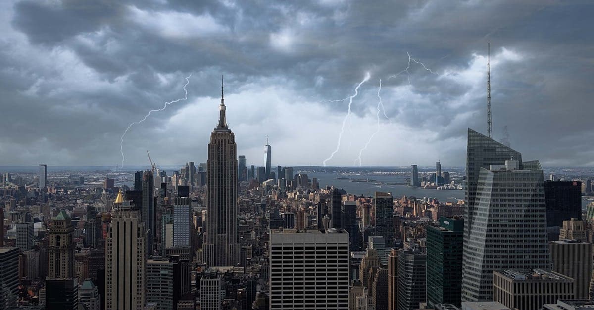 Lightning storm over New York City skyline with Empire State Building illuminated at night.