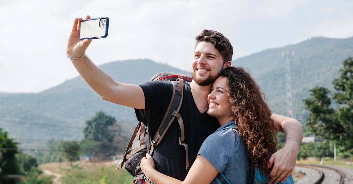 Couple with hiking backpacks taking a selfie while using the best travel sim card abroad