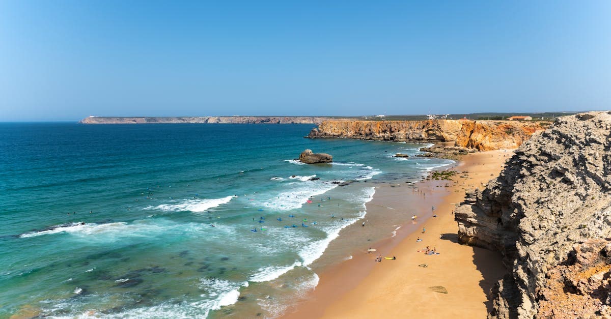 Praia de Sagres com falésias dramáticas e oceano azul, entre as melhores things to do in algarve portugal