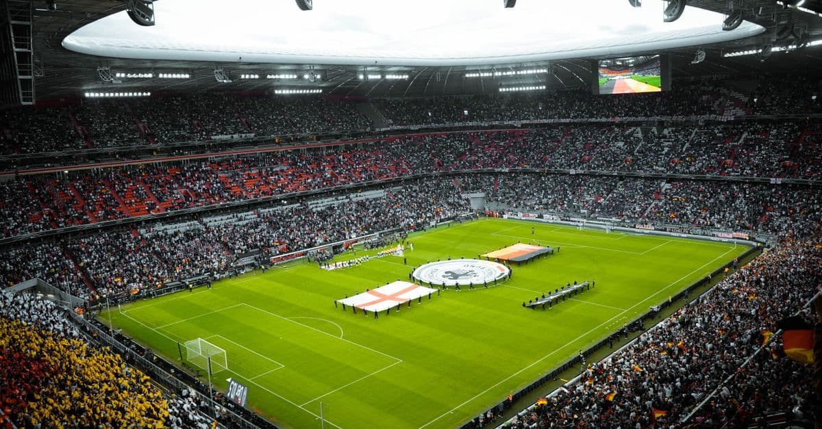 Vollbesetztes Fußballstadion mit jubelnden Fans und Fahnen – historischer Moment bei der Fußball WM 2026