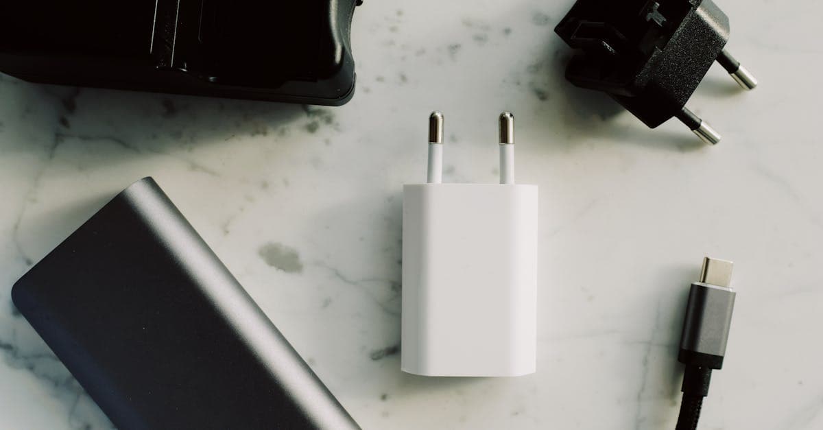Verzameling universele reisadapters en USB-C opladers op een marmeren ondergrond voor gebruik op vakantie.