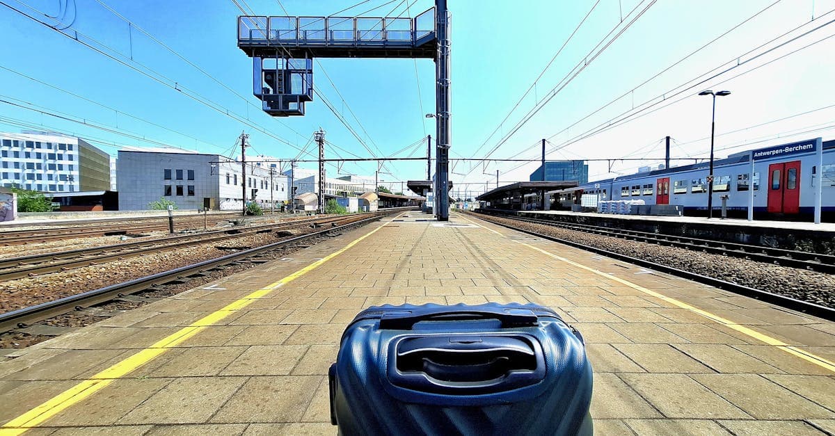 Moderner Koffer auf dem Bahnsteig von Antwerp-Berchem unter Sonnenschein symbolisiert vollständiges Koffer packen.