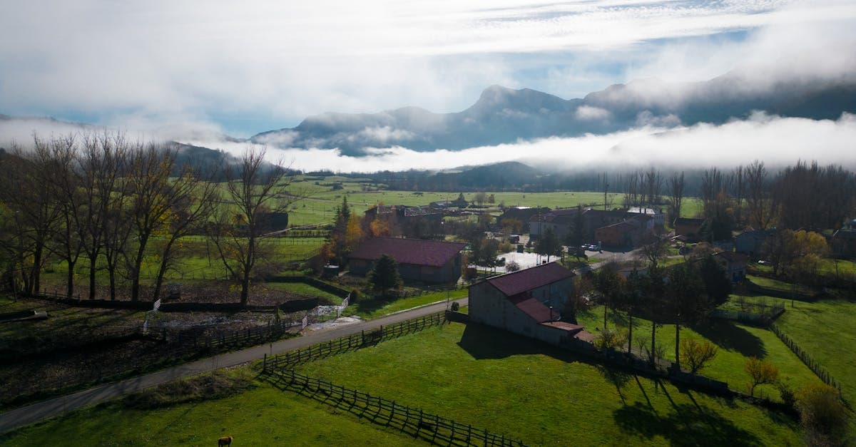Paisaje rural de Riaño con granjas entre montañas y niebla, opciones de alojamiento económico para viajar barato europa
