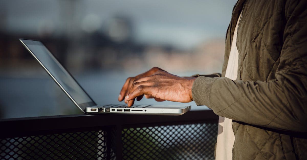 Man arbetar på laptop utomhus med stadspanorama – Fair Use Policy begränsar dataroaming vid högt datanyttjande.