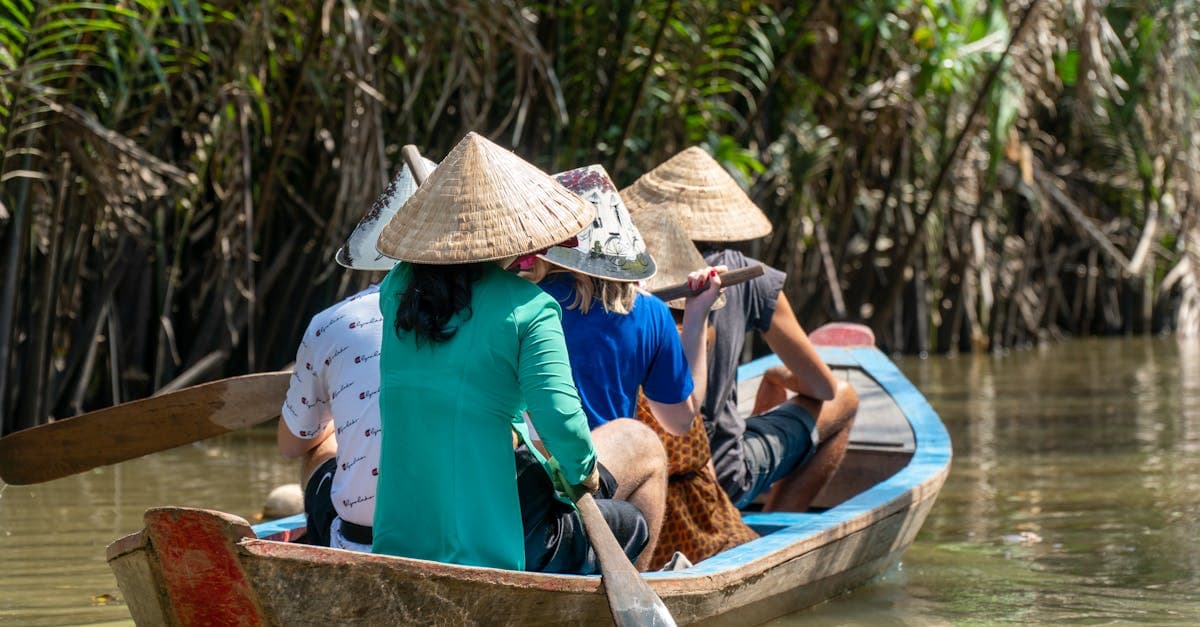 Người địa phương chèo thuyền đội nón lá trên sông Mê Kông trong chuyến day trip từ Sài Gòn về miền Tây.