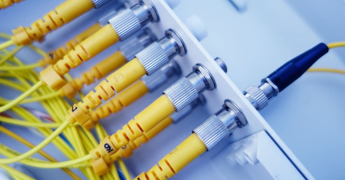 Cavi in fibra ottica gialli in un server di rete, tecnologia alla base della connessione fibra FTTH e FTTC.