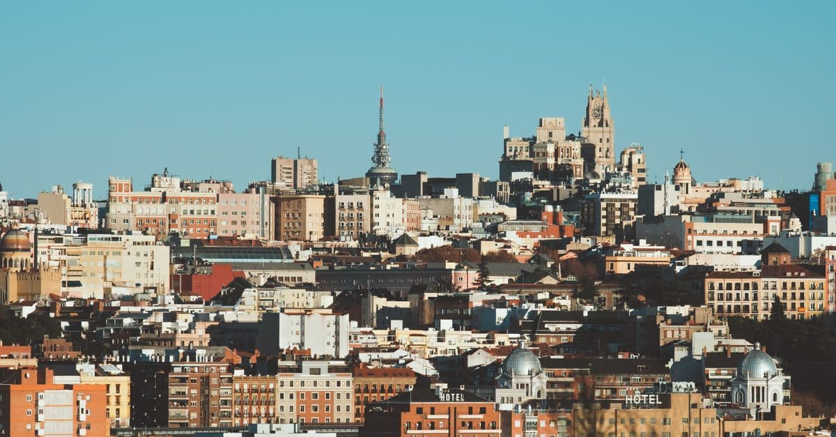 Panorâmica da arquitetura diversificada de Madrid sob céu limpo e azul, perfeita para conhecer o tempo em Madrid.