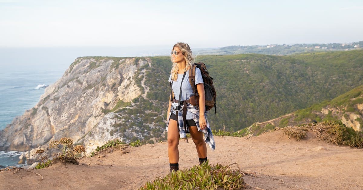 Mulher caminhando pelas falésias costeiras de Portugal seguindo o checklist para a primeira viagem solo feminina