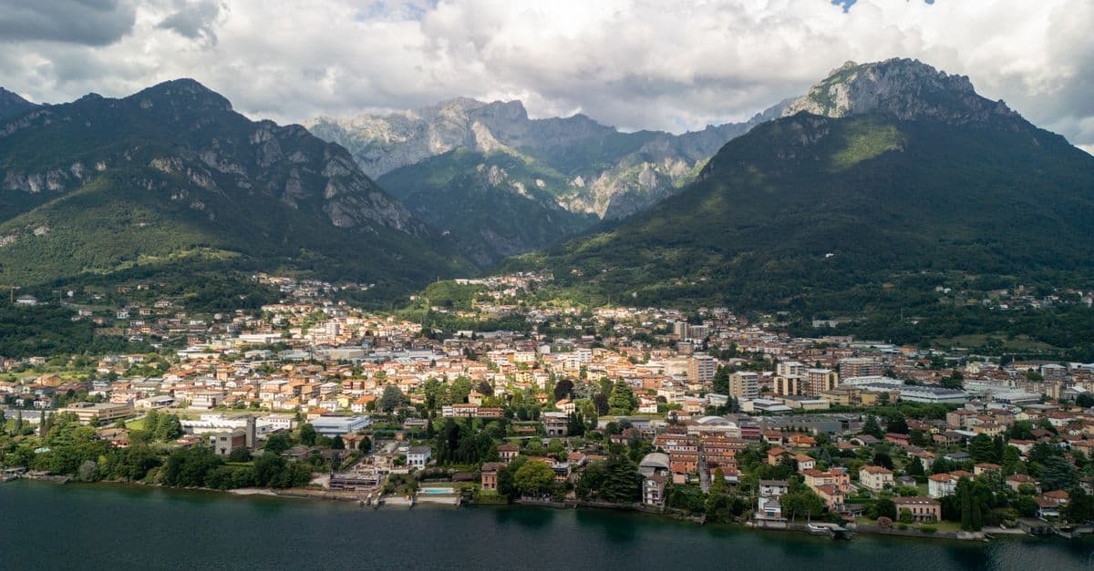 Veduta aerea di un pittoresco borgo lacustre italiano circondato da montagne, zona UAS verificabile su d-flight