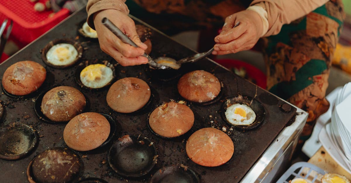 Street vendor preparing traditional Vietnamese egg cakes at an outdoor stall in Bình Thuận