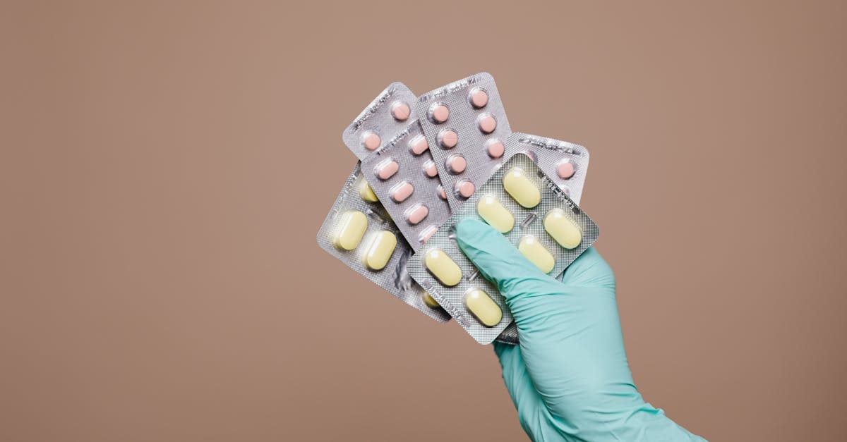 Close-up of a gloved hand holding blister packs of tablets, a must for any packing list for holiday
