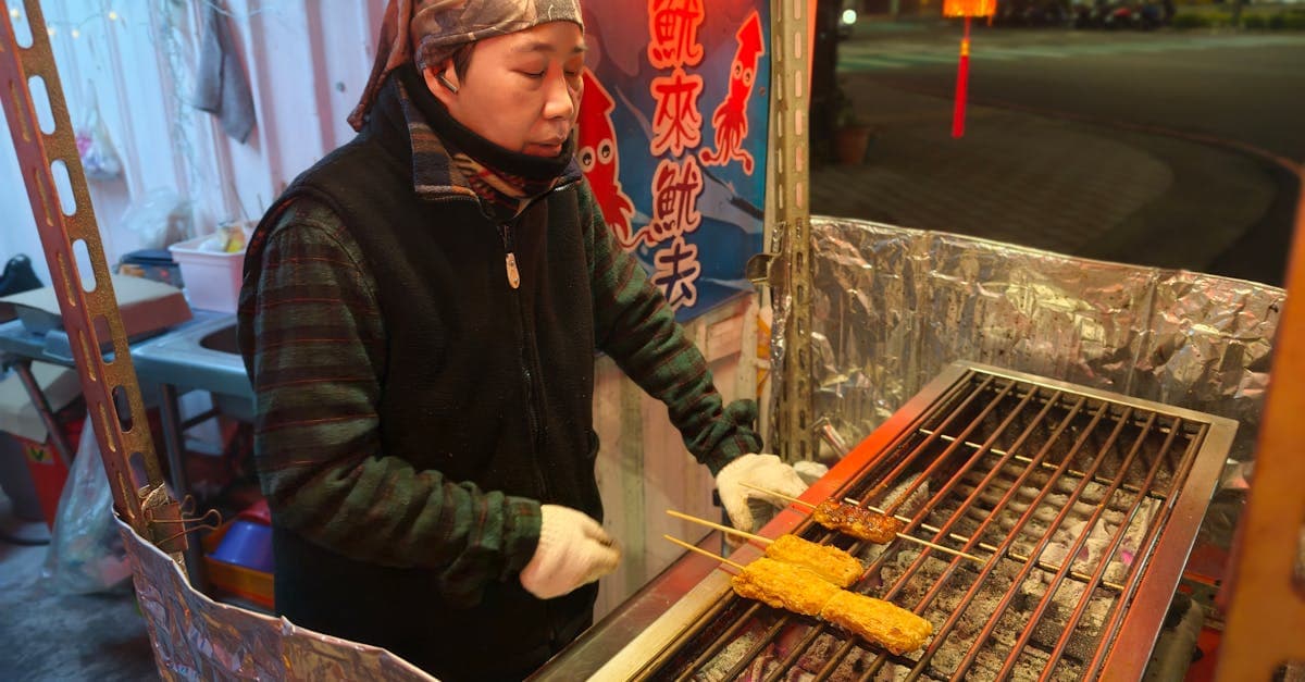 台湾の夜市で串焼きを焼く屋台、煙と香りが漂うグルメスポットの賑やかな雰囲気