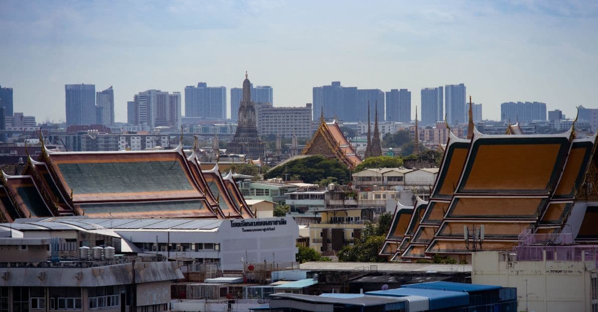 Bangkoks skyline med traditionell thaiarkitektur och moderna skyskrapor sida vid sida.