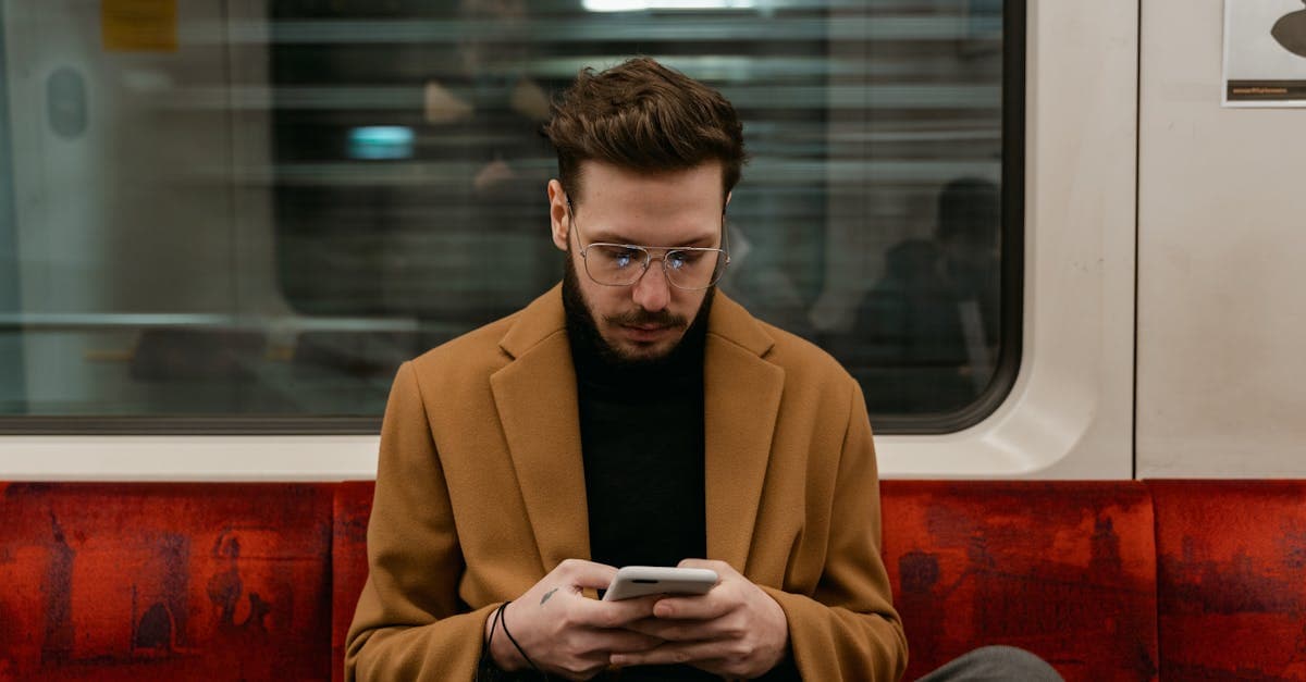 Trenin içinde mobil wifi ile eSIM seçeneğini karşılaştıran, akıllı telefon kullanan kahverengi ceketli bir adam.