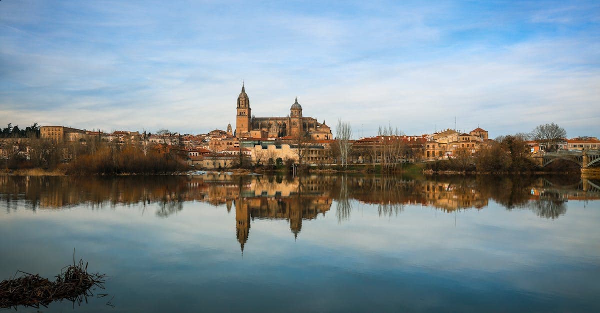 Catedral de Salamanca reflejada en el río Tormes, arquitectura histórica en uno de los destinos baratos de Europa