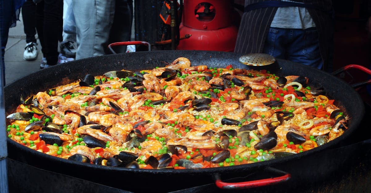 Traditional Spanish paella with rice, bright vegetables, and shellfish, showcasing what to eat in Spain's coastal regions