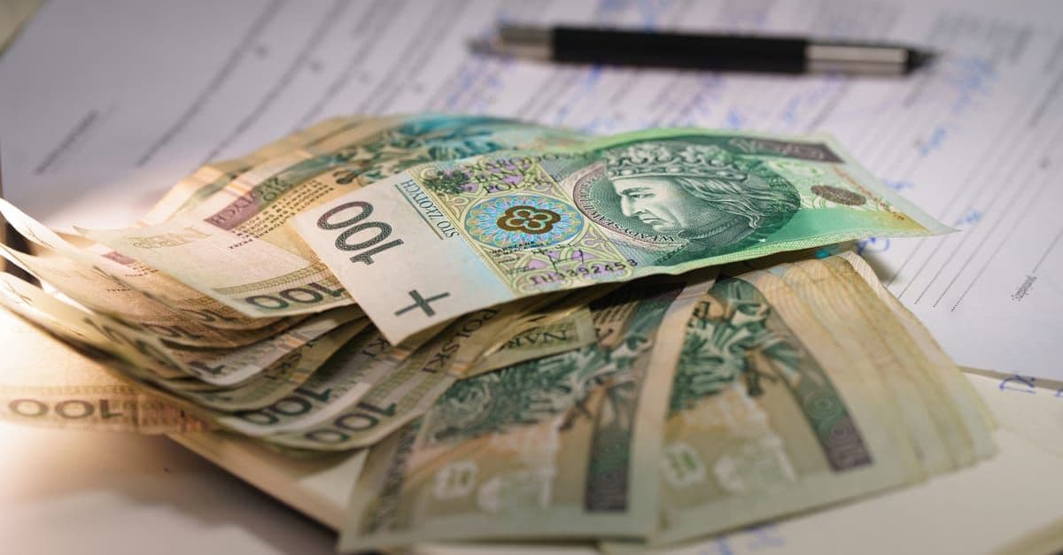 Plik banknotów złotówkowych na dokumentach finansowych – zarobki uczestników programu work and travel w USA