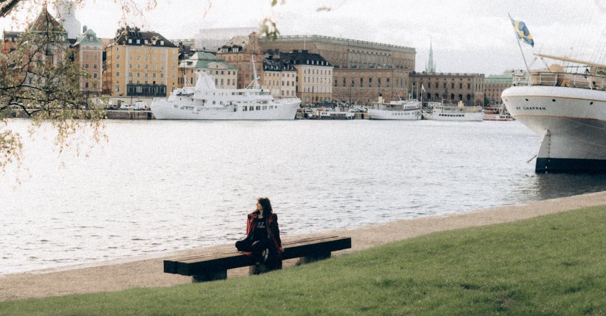 Person sitter på bänk vid Stockholms strandkant och blickar ut över vattnet – guide om svensk skatt vid utlandsarbete