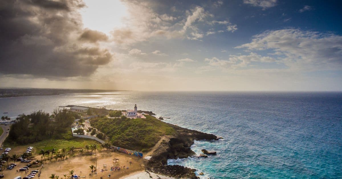 Aerial view of Rincón lighthouse and tropical beach, a breathtaking destination for flights to Puerto Rico.