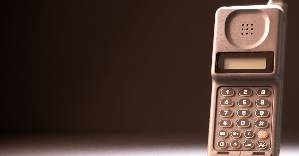 Vintage mobile phone with physical keypad and antenna on a dark background, highlighting retro technology.