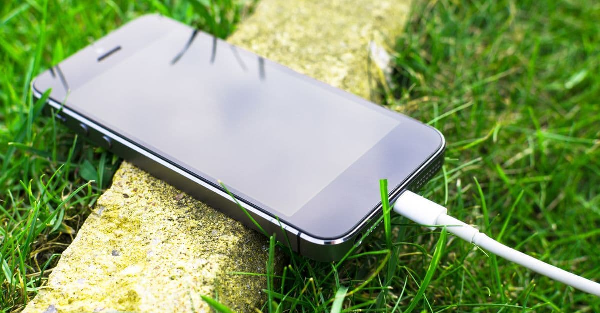 Smartphone resting on grass outdoors representing managing travel eSIM data usage while traveling