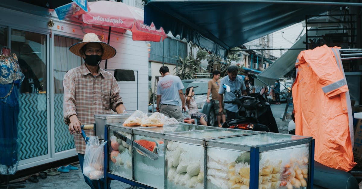 Straßenhändler verkauft frisches Obst vom Karren auf einem typischen Bangkoker Streetfood-Markt