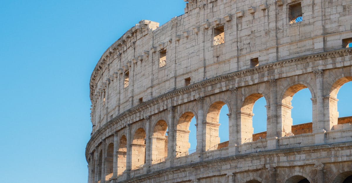 Rome's iconic Colosseum rising against a vivid blue sky, a must-see ancient landmark